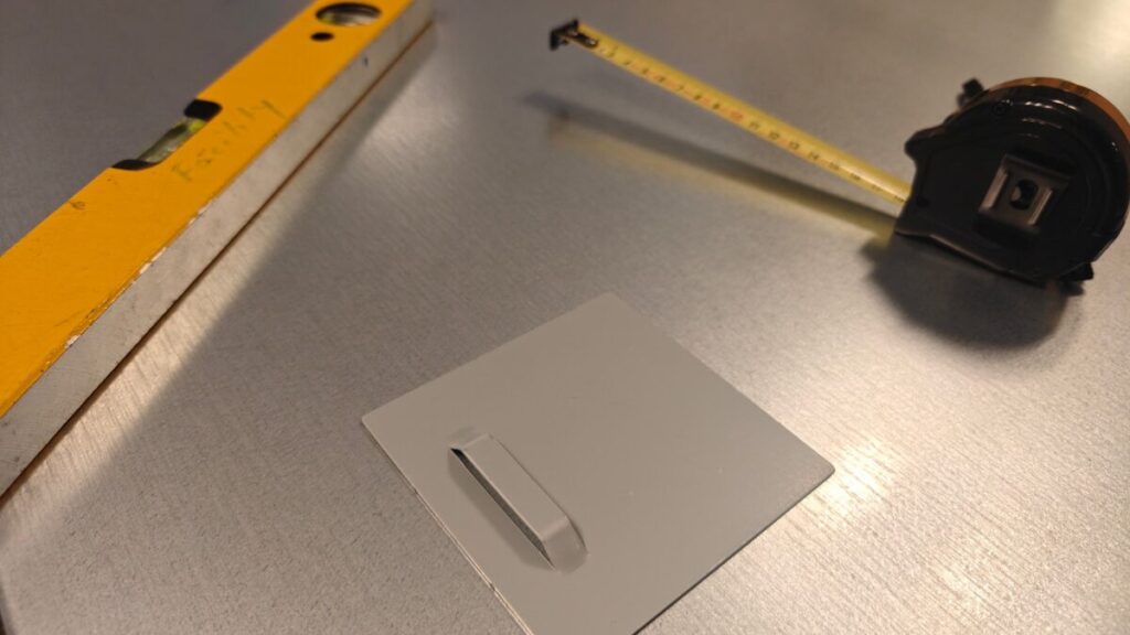 Ophangplaatje voor het magneetbord, met waterpas en rolmaat